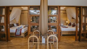 A room with two beds, each with a canopy, wooden furniture, and large windows. - L.Good Lembongan Island Villas (Lembongan Island)