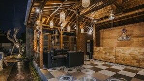 A covered outdoor seating area with a checkered floor, wooden beams, and hanging light fixtures. - L.Good Lembongan Island Villas (Lembongan Island)