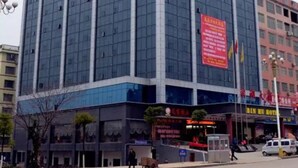 A multi-story building with a glass facade, featuring a prominent red sign on the side. - Yongzhou Binhu Hotel (Yongzhou)