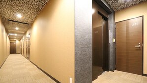 A hotel corridor with a patterned ceiling, a textured wall, and a wooden door marked '307'. - Tokyo Tourist Inn (Tokyo)