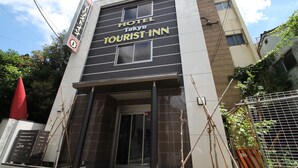 En modern byggnad med en skylt som visar texten ”Hotel Tokyo Tourist Inn”.