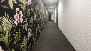 Um corredor com papel de parede floral e piso coberto de carpete.