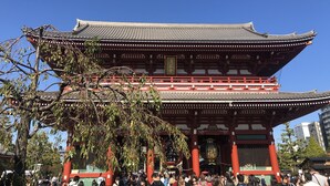 En traditionell japansk byggnad med flera våningar och röda pelare.