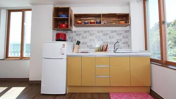 A compact kitchen with a white refrigerator, wooden cabinets, and a tiled backsplash.
