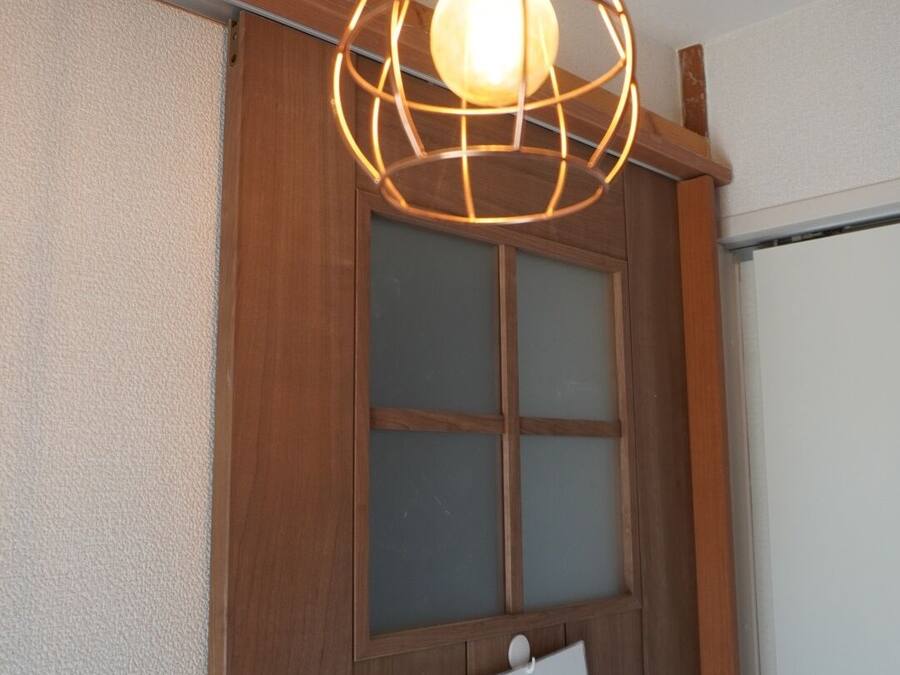 A wooden door with a 'VACANT' sign and a hanging light fixture.