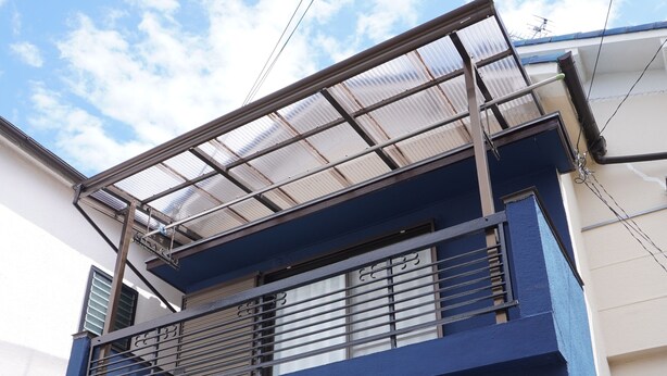 A two-story building with a blue exterior, a metal balcony, and a black door. - Guest House Ioly Osaka - Hostel (Fujiidera)
