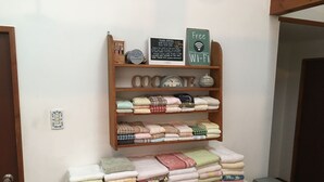 A neatly organized shelf with folded towels and a sign indicating free Wi-Fi. - Pension Cocotte (Takayama)