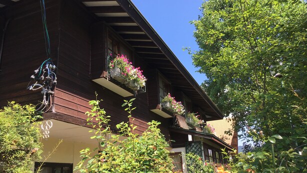 A wooden building with multiple balconies, some with flower boxes and greenery. - Pension Cocotte (Takayama)