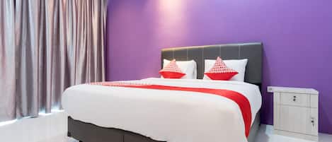 Un dormitorio moderno con una cama grande, paredes moradas y una mesita de noche.