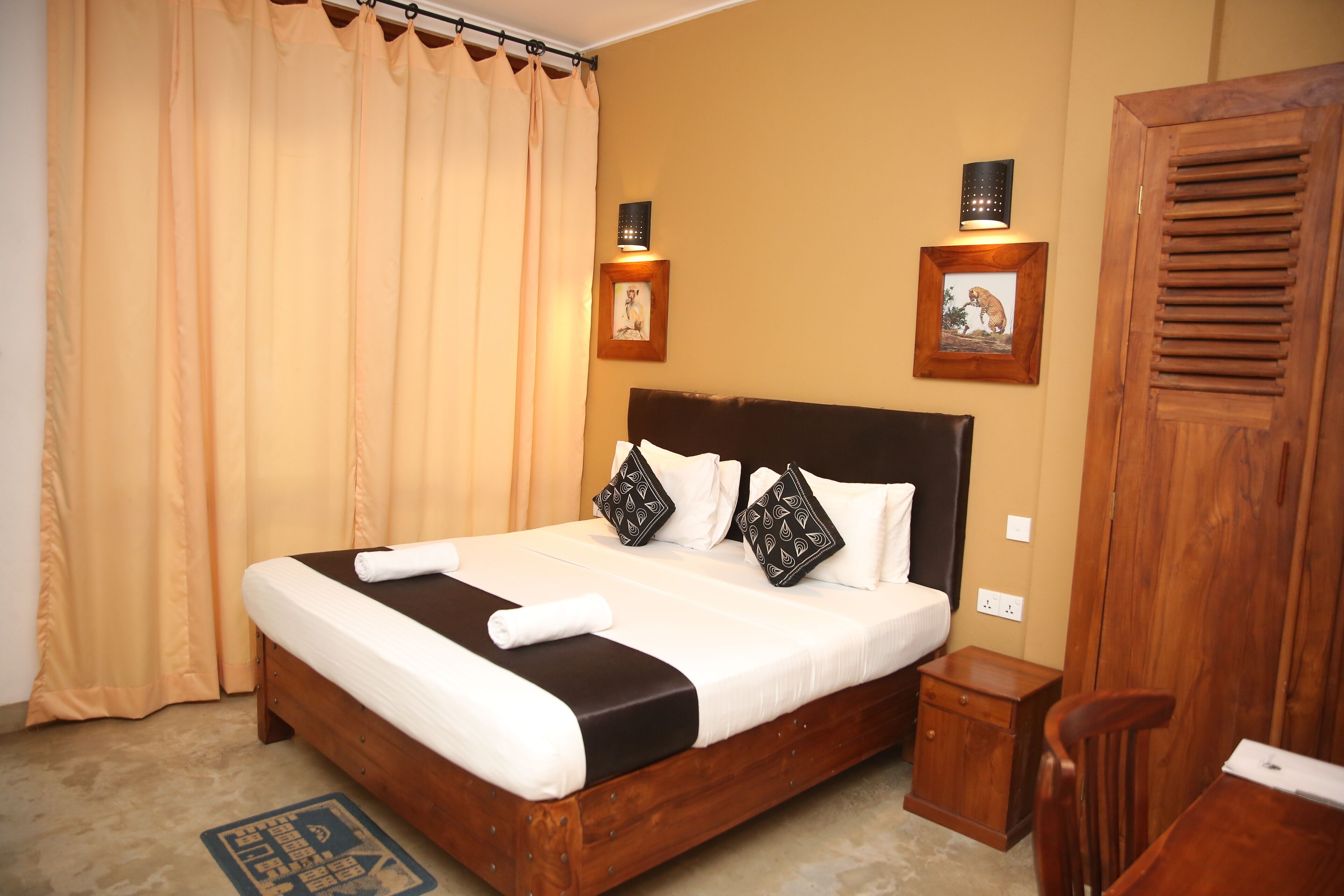 A neatly made bed with a wooden headboard, a bedside table, and a nightstand.