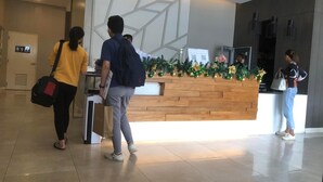 A reception area with a wooden counter, a modern geometric wall design, and a Christmas decoration. - I.T PARK CEBU TWIN BED DELUXE FREE FAST WIFI & POOL (Cebu City)