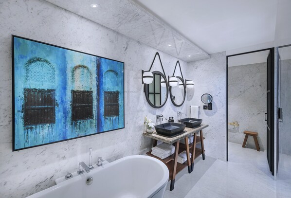 Ein modernes Badezimmer mit einer großen Badewanne, zwei Waschbecken und einem großen abstrakten Gemälde an der Wand.