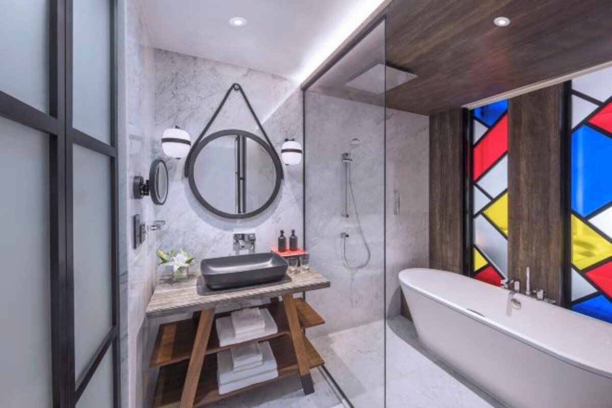 A modern bathroom with a freestanding bathtub, a vanity with a mirror, and a shower.