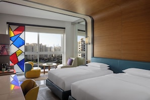 Two large beds with white linens and a wooden headboard offer a comfortable retreat with a city view.