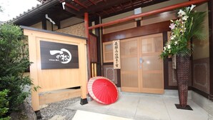 A traditional Japanese entrance with wooden doors, a red umbrella, and a signboard. - Ichinomatsu Japanese Modern Hotel (Takayama)