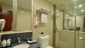 Ein Badezimmer mit Marmorwaschtisch, Toilette und einer Duschkabine.