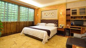 Ein Hotelzimmer mit einem großen Bett, einem Fernseher und einer Holzkommode.