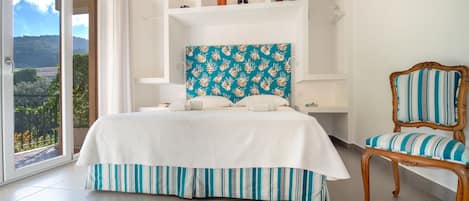 Un dormitorio con cama, una silla y vistas al exterior.