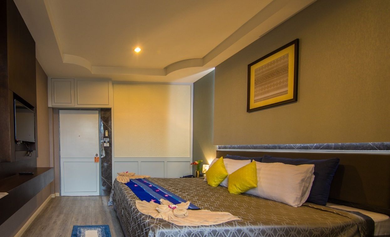 Una habitación de hotel con una cama, un escritorio y una puerta.