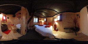 A cozy, circular wooden room with a bed, a small desk, and a window.