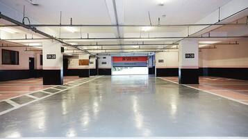 A spacious parking garage with multiple parking spaces, a central walkway, and a hotel entrance labeled "No.25 Hotel".