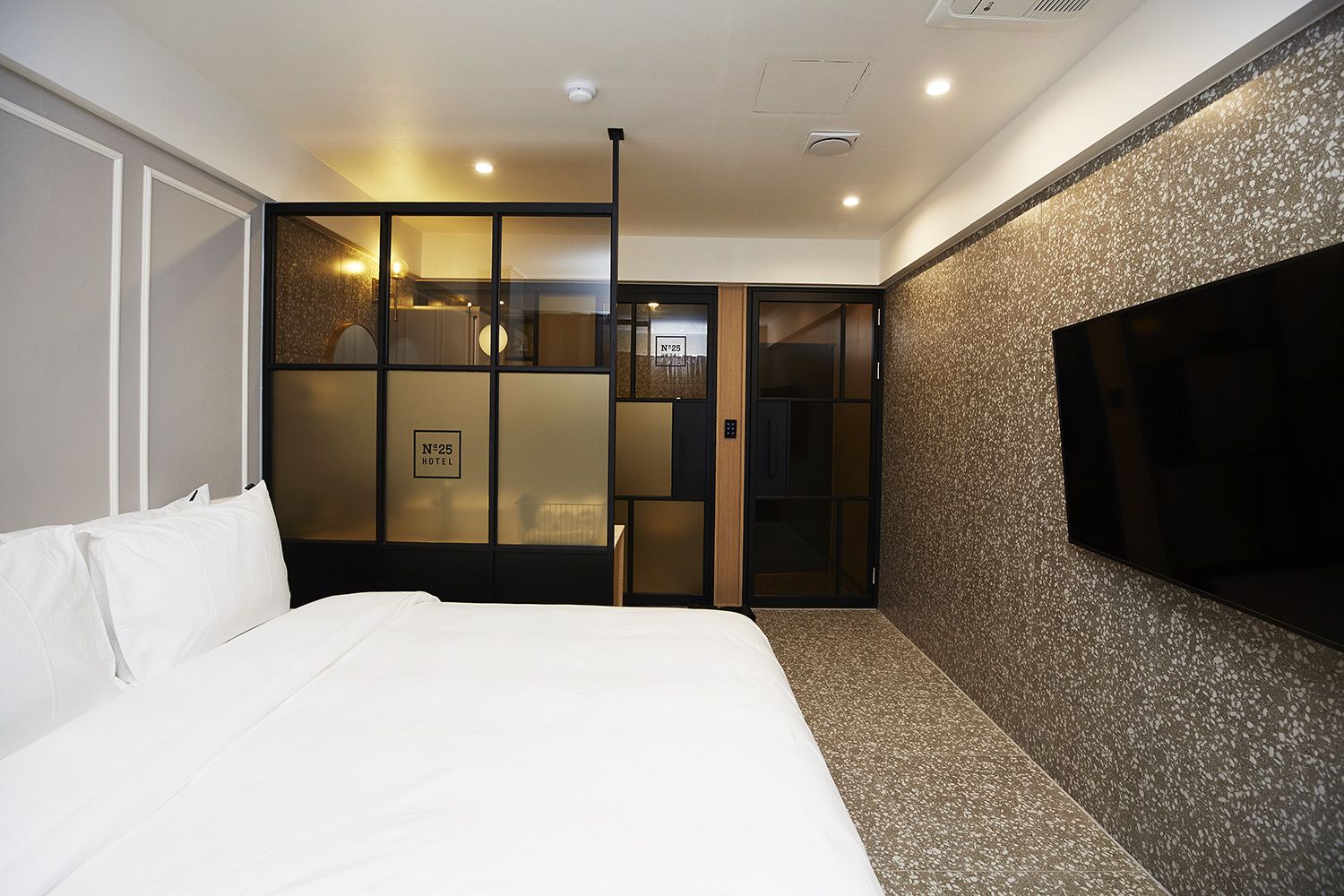 Habitación de hotel con cama, televisor y armario corredero.