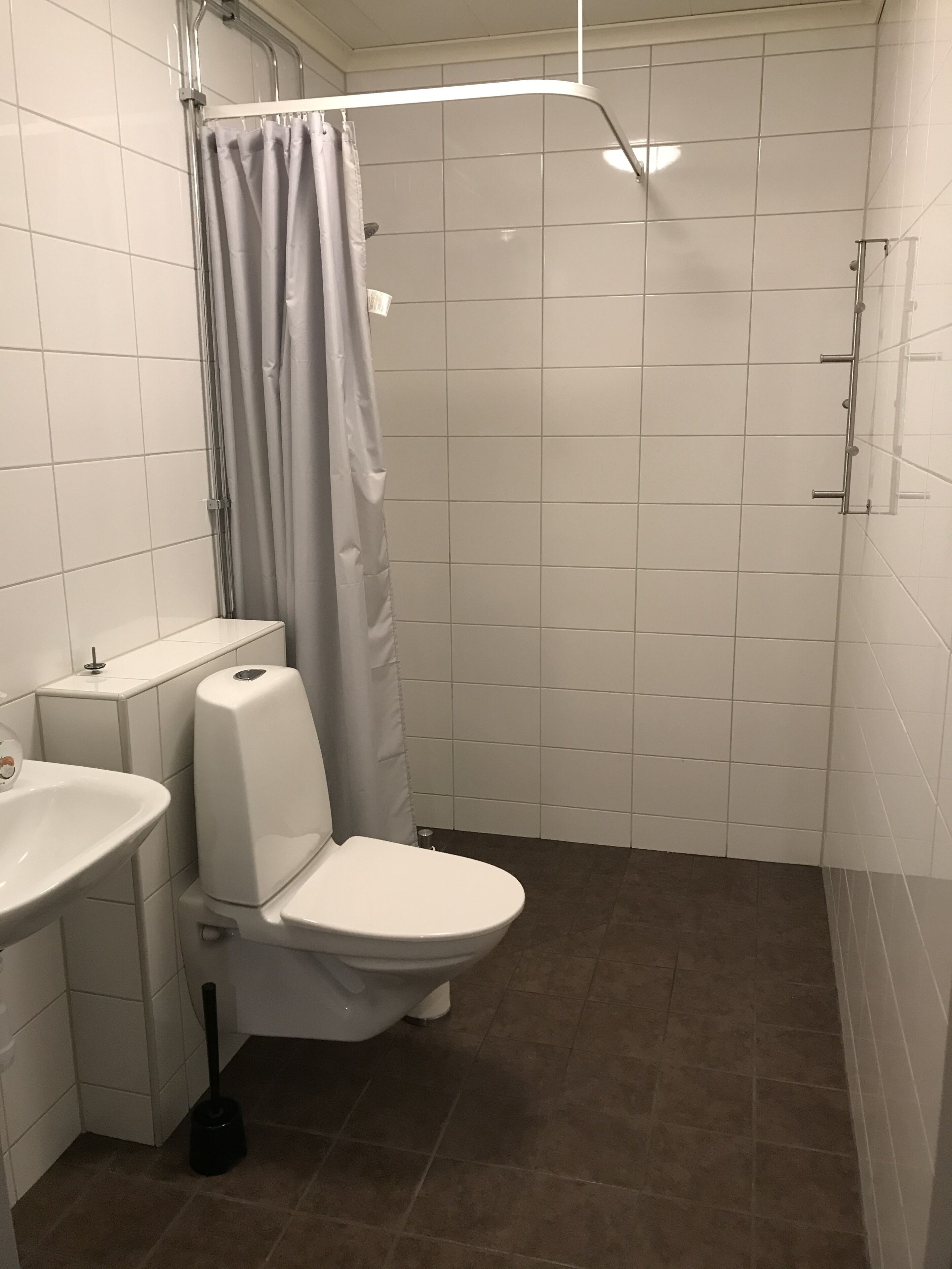 A bathroom with a toilet, sink, and shower.