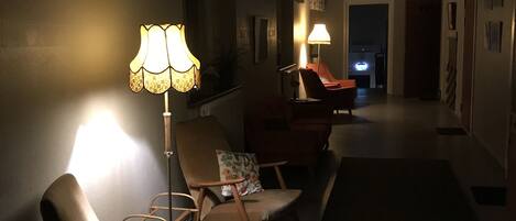 A dimly lit hallway with two chairs and two lamps.