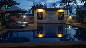 Una piscina al aire libre, sombrillas, tumbonas