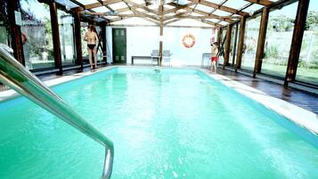 Una piscina cubierta, una piscina al aire libre de temporada, tumbonas