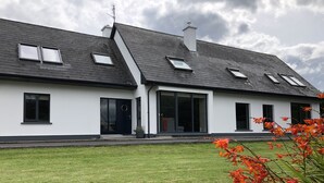 A modern house with a sloped roof, large windows, and a well-maintained lawn. - Westport Coastal Lodge (Westport)