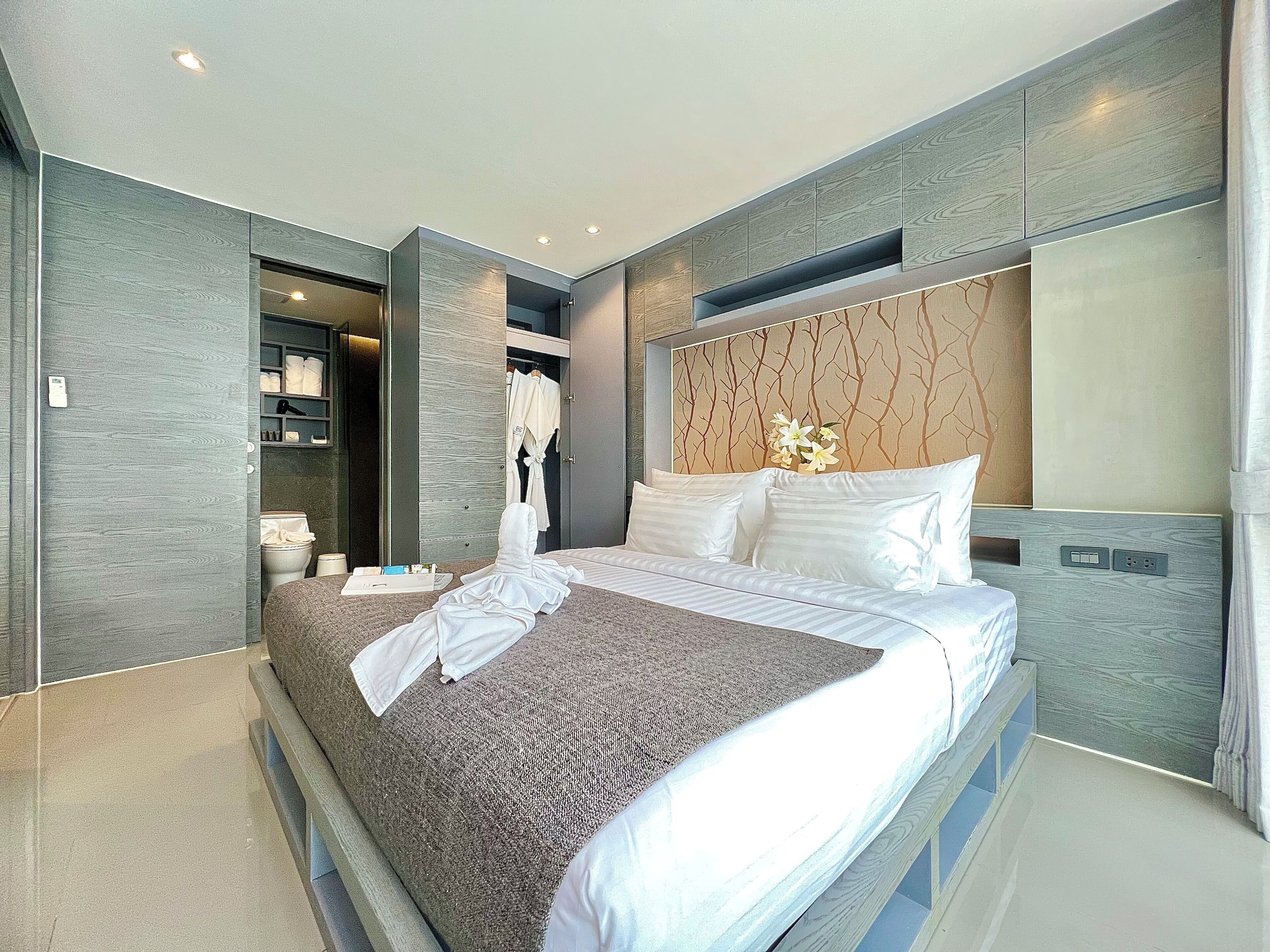 Un dormitorio moderno con una cama grande, armario empotrado y un rincón de tocador.