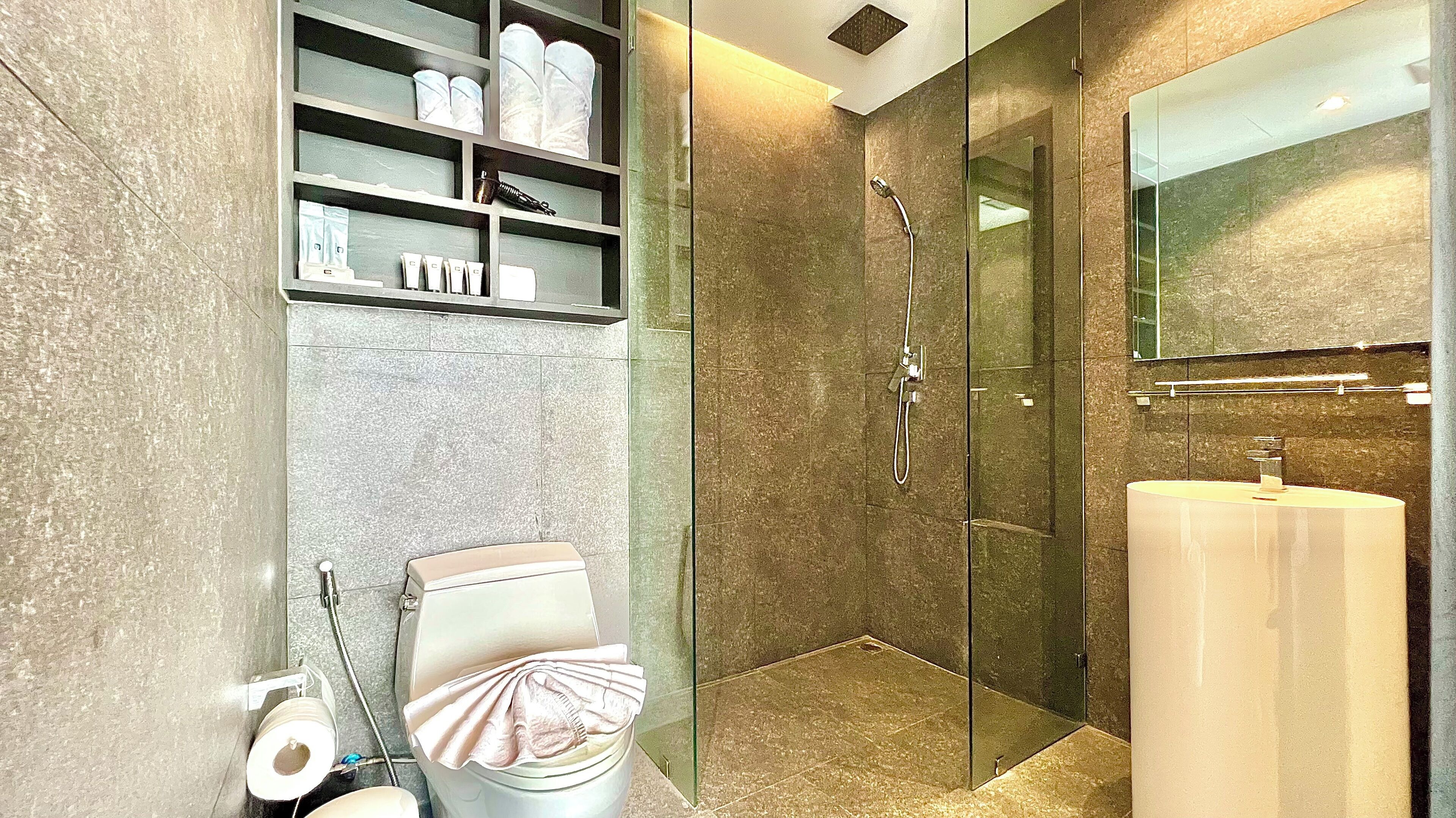 Un bagno moderno con doccia vetrata, un water e un lavandino.