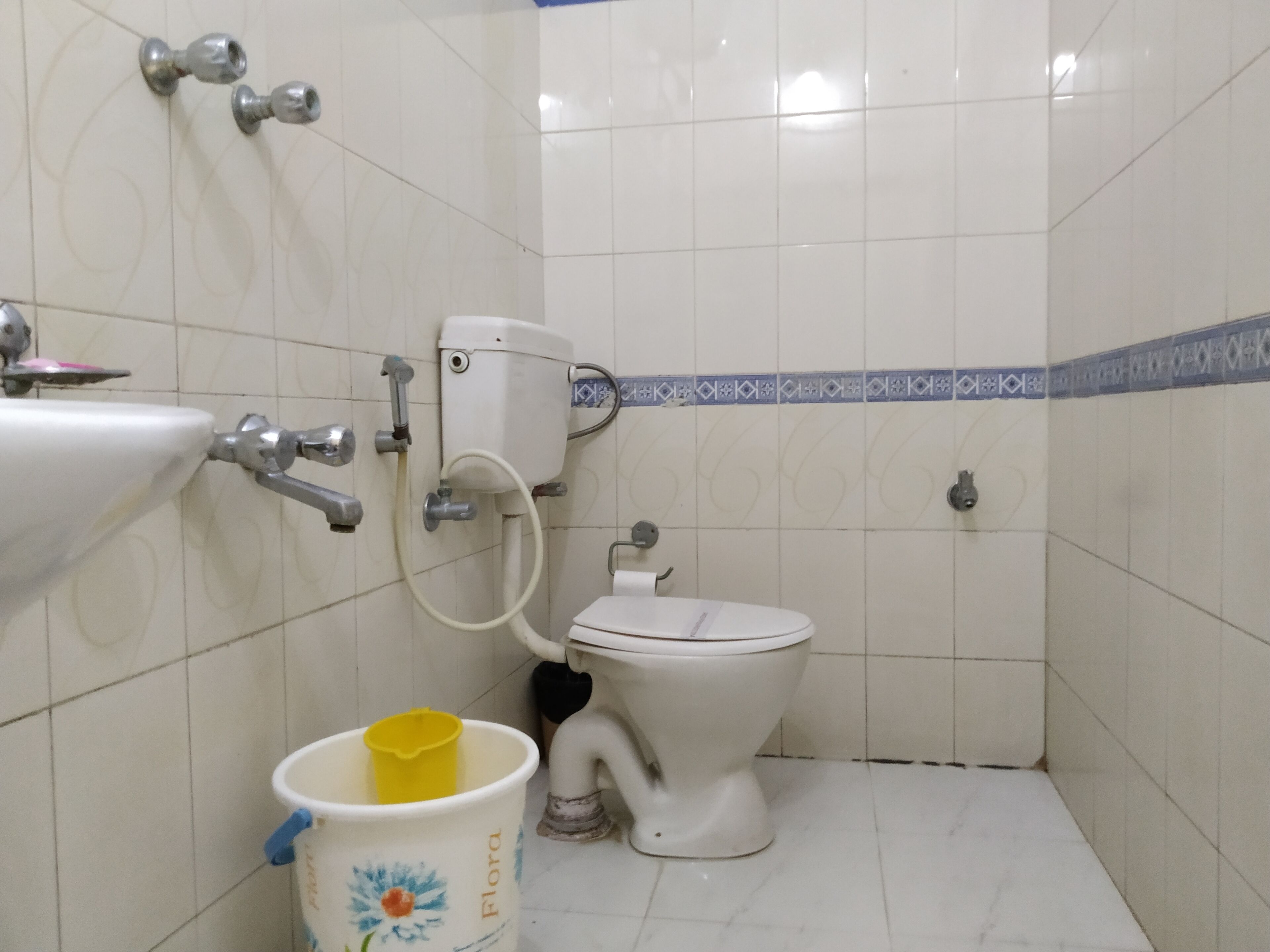 Un baño pequeño con inodoro, lavamanos y ducha.