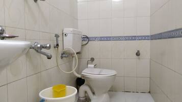Un baño pequeño con inodoro, lavamanos y ducha.