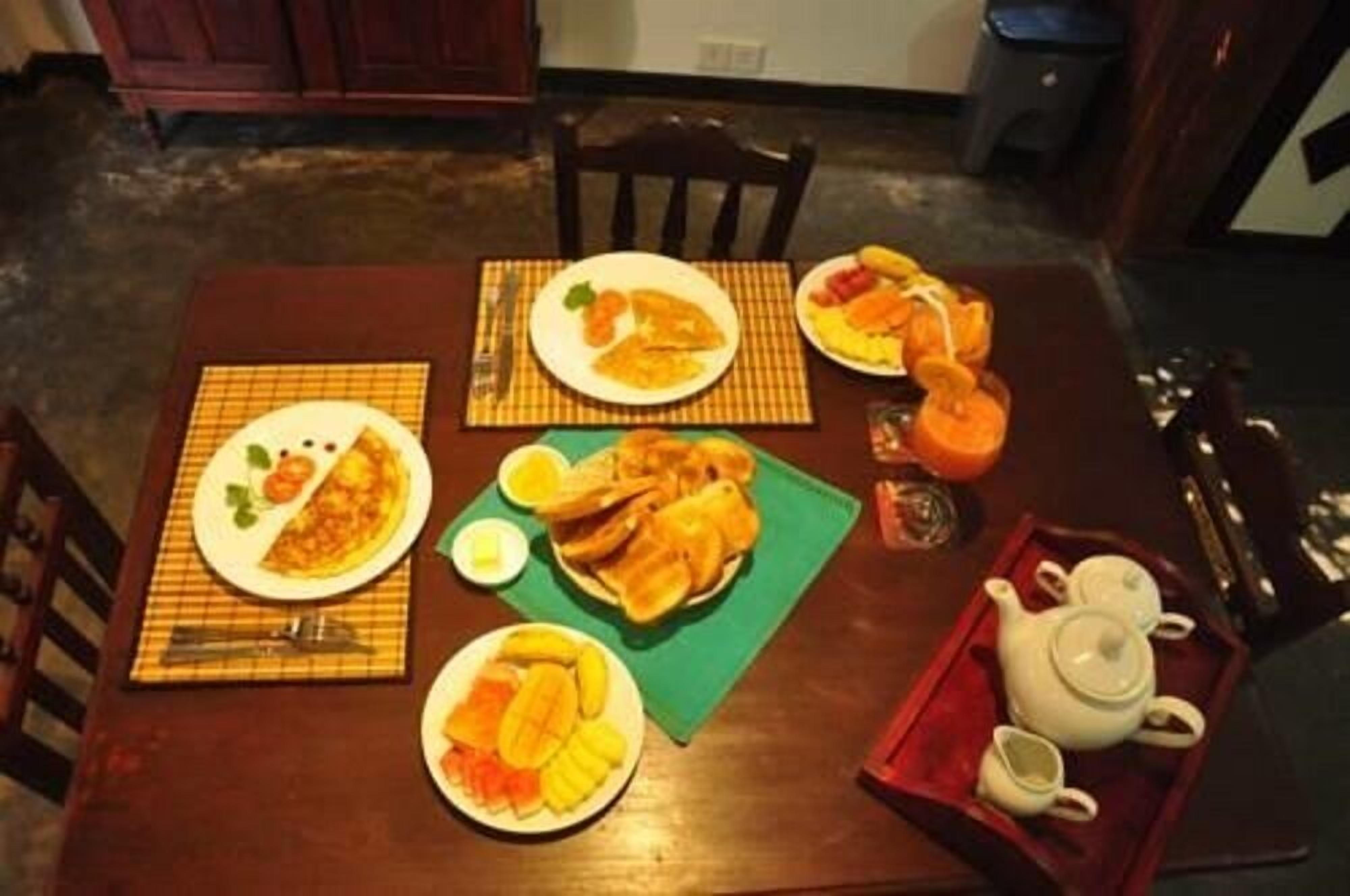 Uma mesa de jantar com pratos de comida, um bule e uma bandeja.