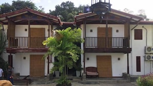 Um edifício de dois andares com piscina em frente.