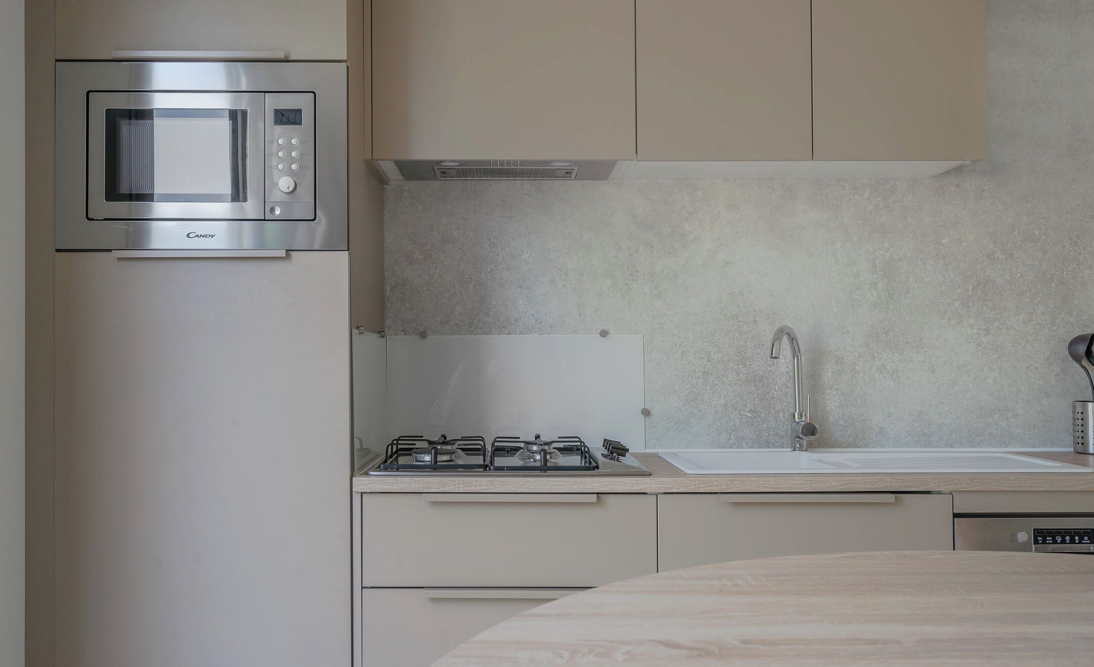 A modern kitchen with a built-in microwave, gas stove, and stainless steel sink.