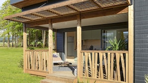 Une maison moderne dotée d’une terrasse en bois, d’une cuisine et d’un coin repas.