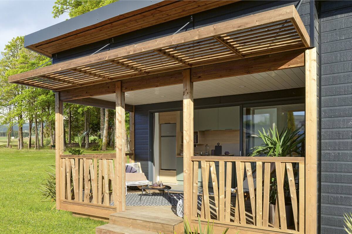 Una casa moderna con una terrazza in legno, una cucina e una sala da pranzo.