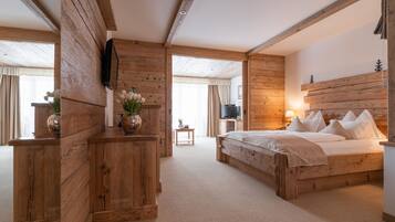 A wooden-themed bedroom with a bed, bedside table, and a television.