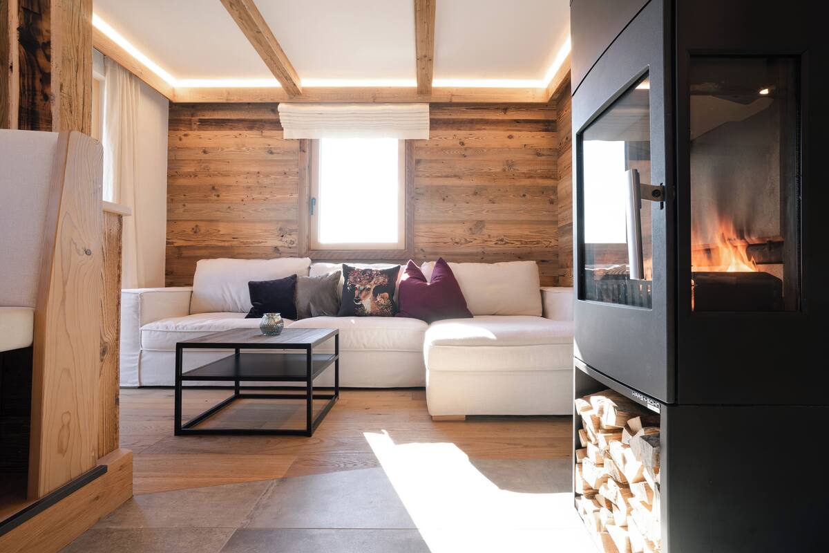 Ein gemütliches Wohnzimmer mit einem weißen Sofa, einem Couchtisch und einem Kamin.