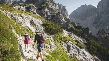 A mountainous hiking trail with rocky terrain and sparse vegetation.