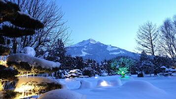 Surrounded by snow-covered trees and a serene mountain backdrop, this peaceful scene invites relaxation.