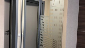 Una stanza con una porta scorrevole in vetro, pavimento in legno e un lampadario.