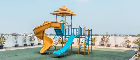A playground with two slides and a climbing structure.