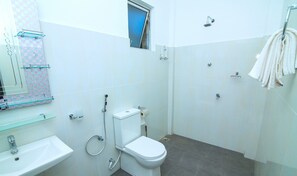 A bathroom with a toilet, sink, and shower. - Hotel Sun Blue (Trincomalee)