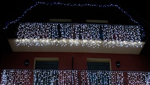 A hotel with a sign reading "Hotel Ethos." It features a balcony with string lights and a double door entrance. - Hotel Eth Saueth (Naut Aran)