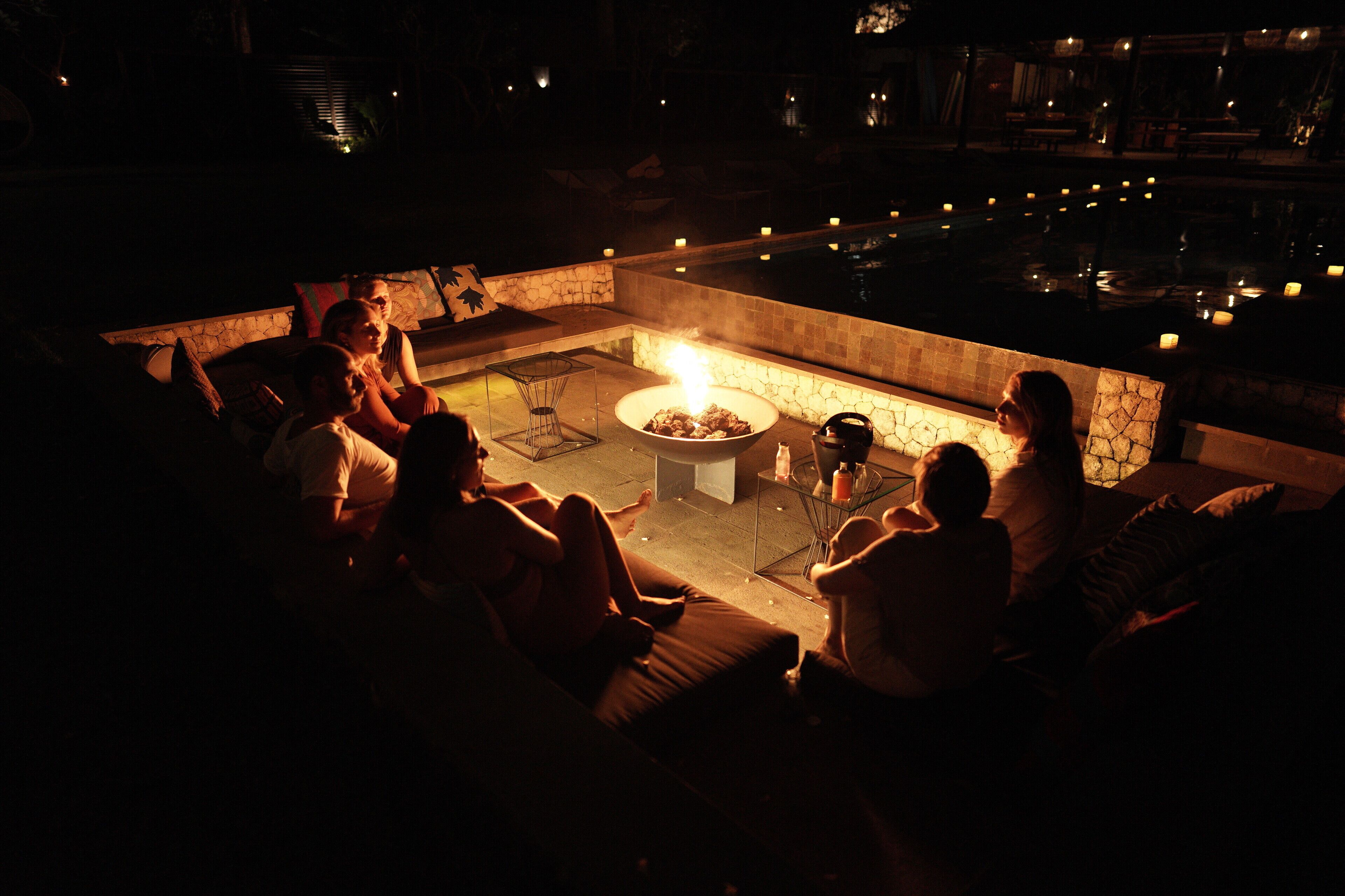 Un área de estar al aire libre con una chimenea y una piscina.