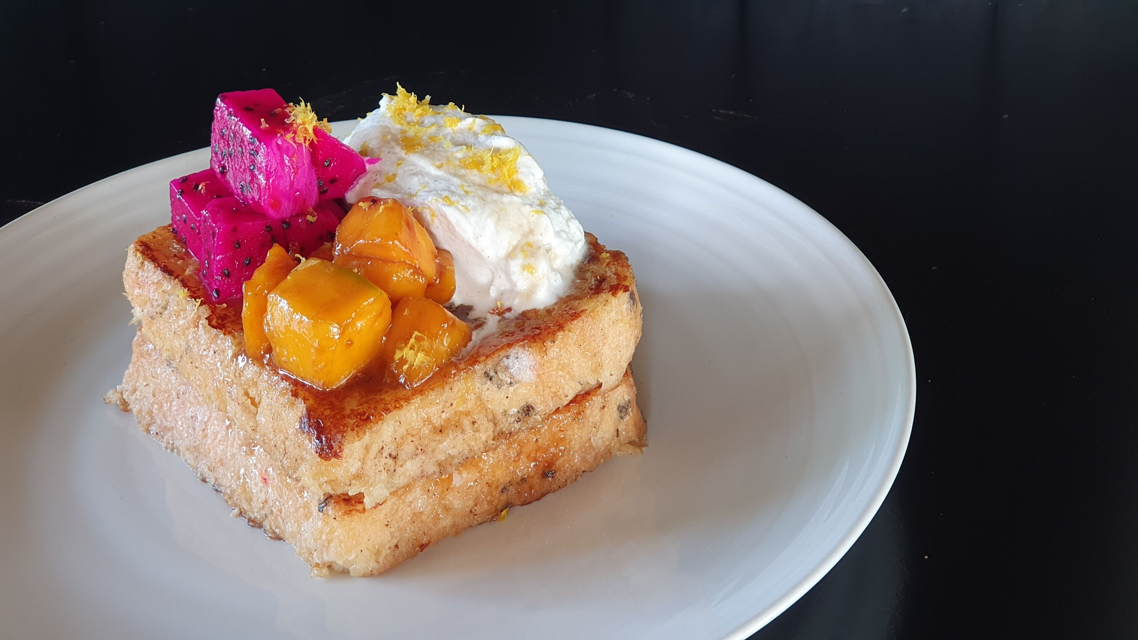 A slice of cake with fruit toppings on a white plate.